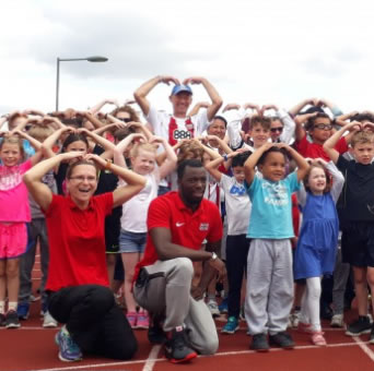 kids and adults doing a Mo Farah dance