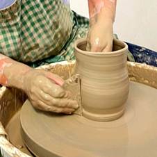 A person working on a pottery wheel  Description automatically generated